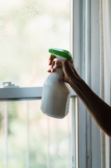 Žmogus valantis langą mikropluošto šluoste, kad neliktų dryžių