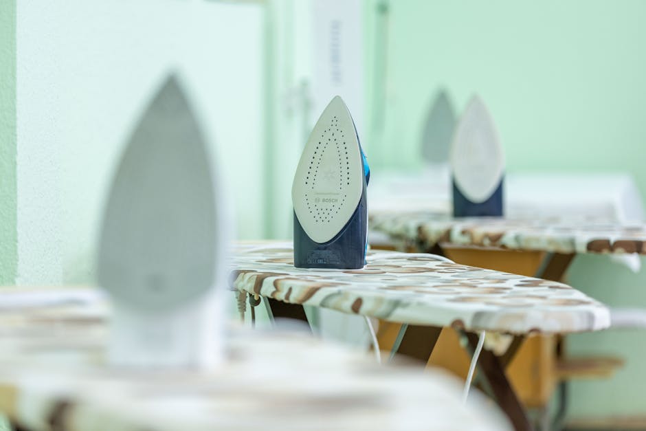 Lygintuvas su apsauginiu audiniu ant lentos išlyginant apykaklę