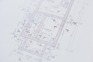 Gili ir greita namų renovacijos planavimo logika: rankoje skaičiuotuvas, darbų sąmata ir realus grafikas ant planšetės.