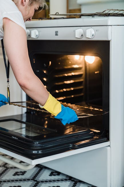 Sodos pasta tepama ant orkaitės durelių, matomi riebalų dėmių valymo veiksmai